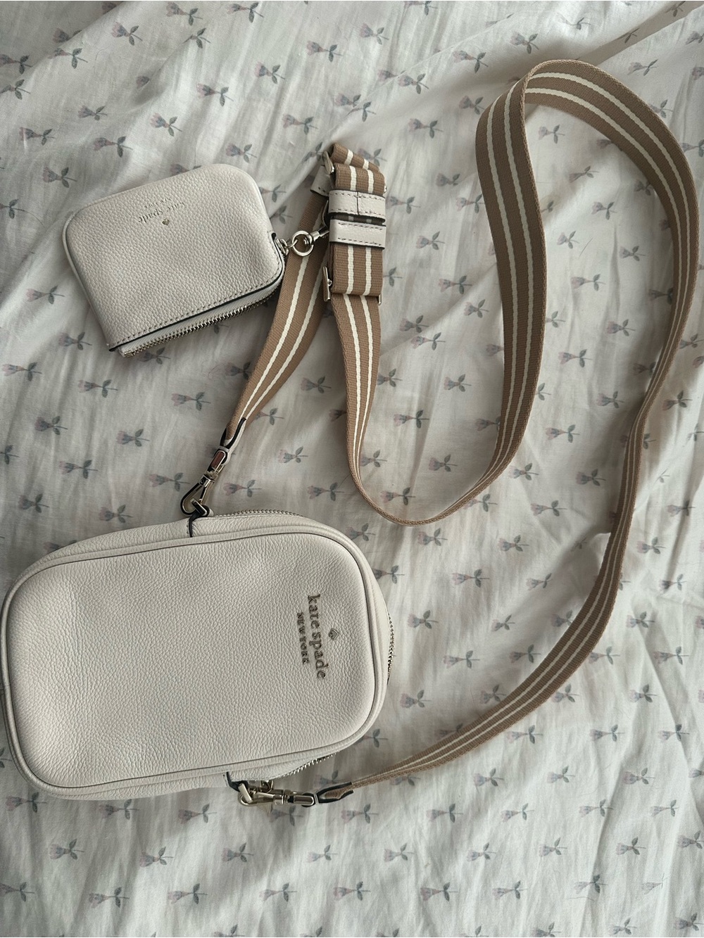 Kate Spade cream crossbody bag with tan striped strap and attached card holder